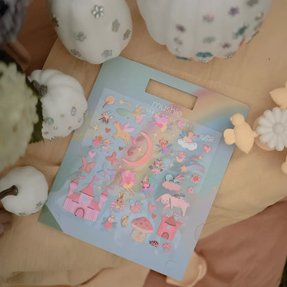 Wiederverwendbares sticker set feen mit pastellblauen aufklebern und märchenhaften feen, schloss und tiermotiven in rosa und lila