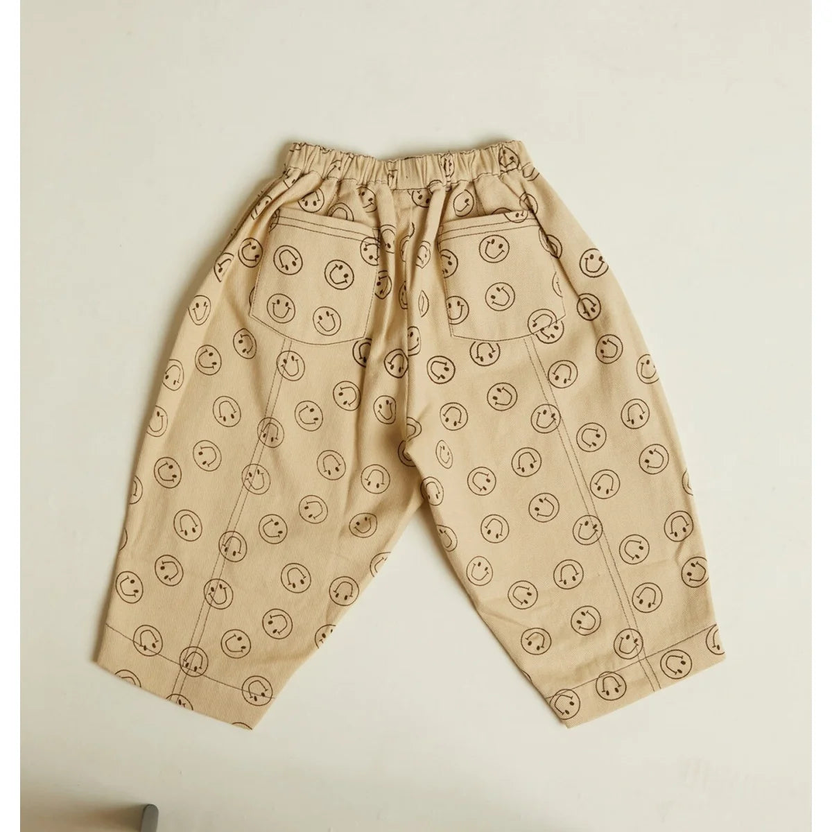 Beige rex joy butter trouser mit elastischem bund und verspieltem schwarzem smiley muster