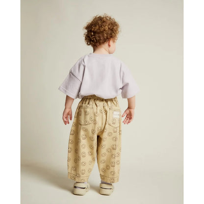Beige rex joy butter trousers mit elastischem bund und schwarzen smiley mustern vorne mit taschen