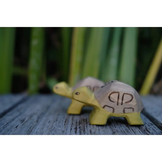 Handgefertigte kleine Schildkröte aus Holz mit gelbem Körper und grauer Schale