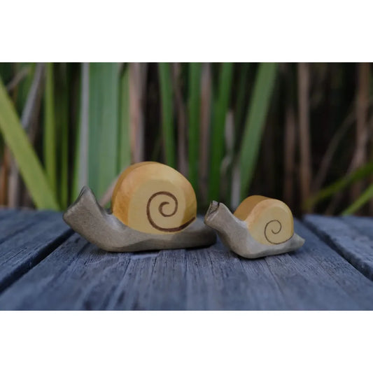 Zwei dekorative Schneckenfiguren mit spiralförmigen Schalen auf der Produktseite Schnecke