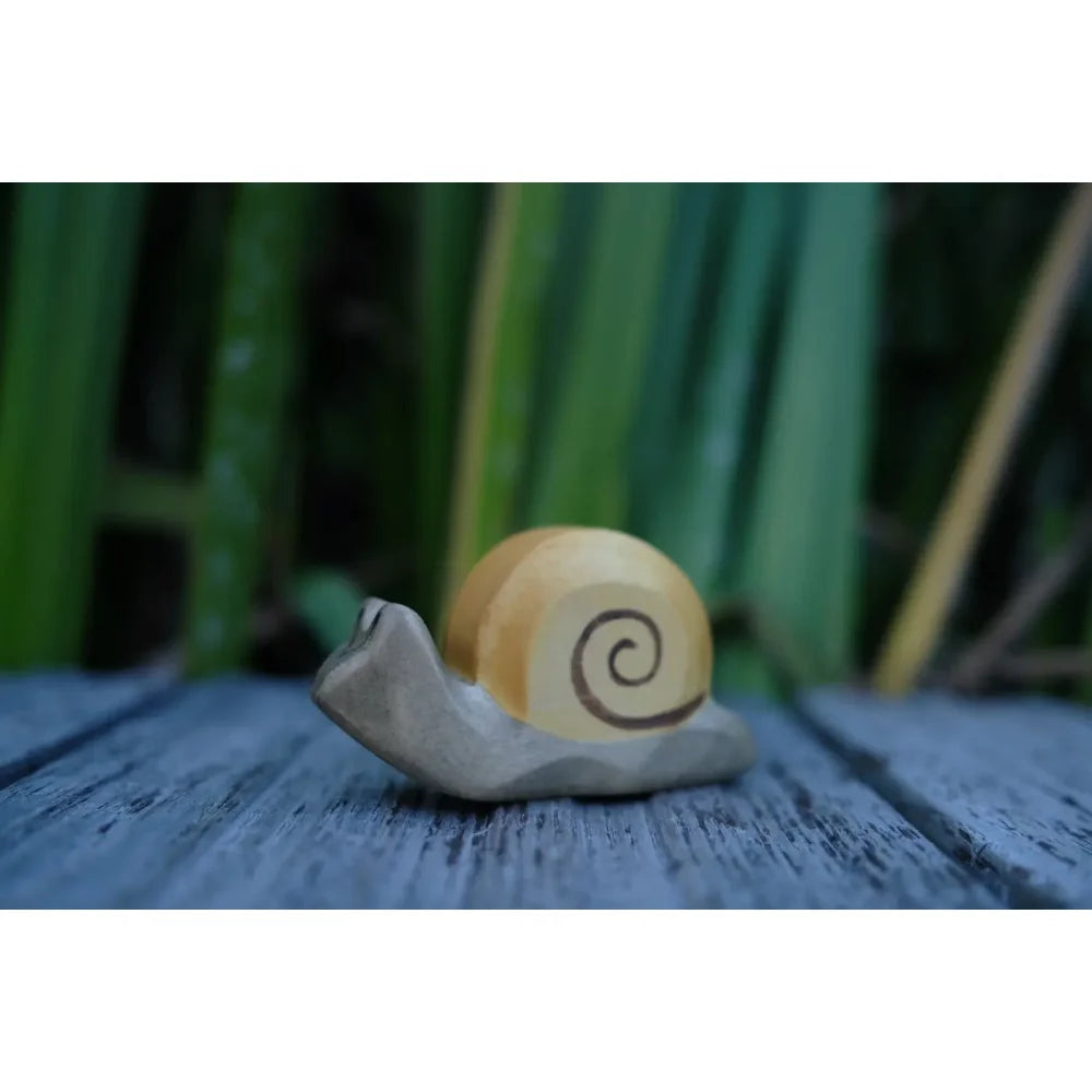 Helle Holzschnecke mit dunklem Spiralmuster als Dekorationsfigur