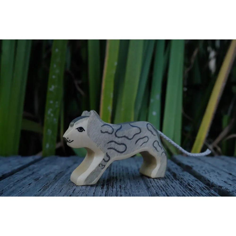 Kleines Holzspielzeug Schneeleopard mit grauen Flecken und dünnem Schwanz