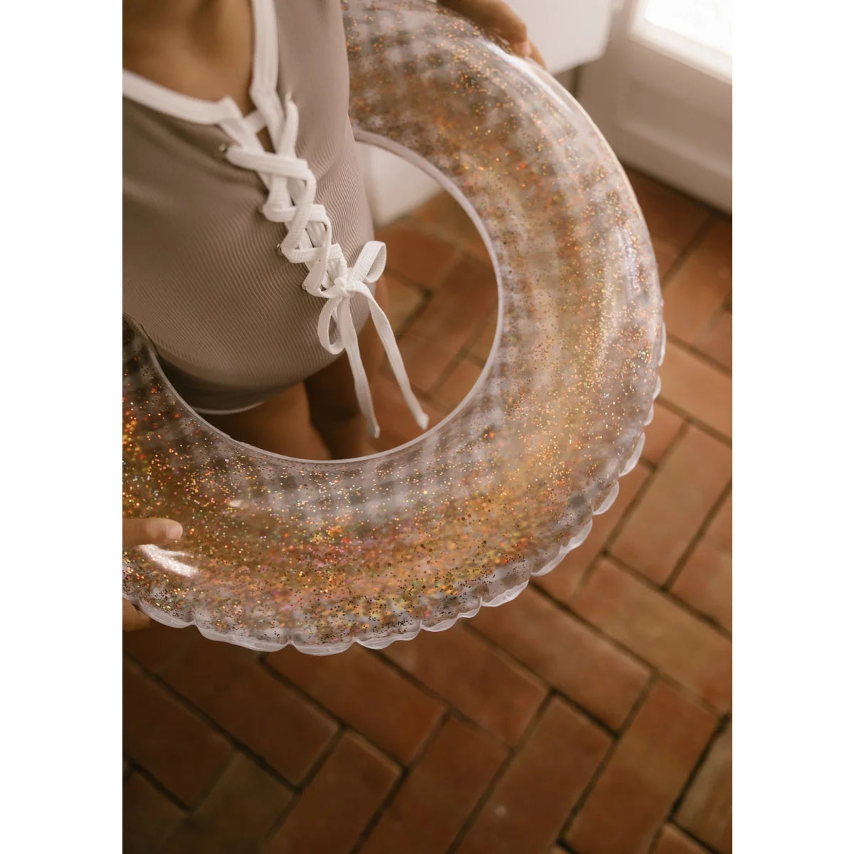 Klarer schwimmring love confetti mit gold- und mehrfarbigen glitzerwirbeln und gewelltem rand nachhaltige babykleidung schweiz