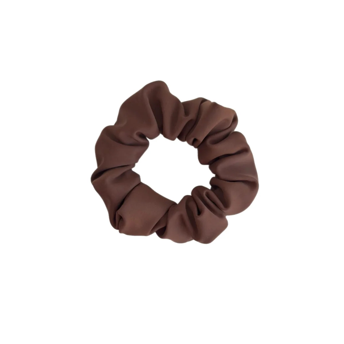Ein weiches, mattes braunes stoffscrunchie mit geraffter, gerippter textur aus der mini + me | mocha kollektion