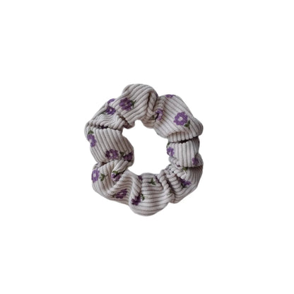Ein weiches graues kordstoff scrunchie mit zarten violetten blumenmustern aus der kollektion scrunchies mini + me violet