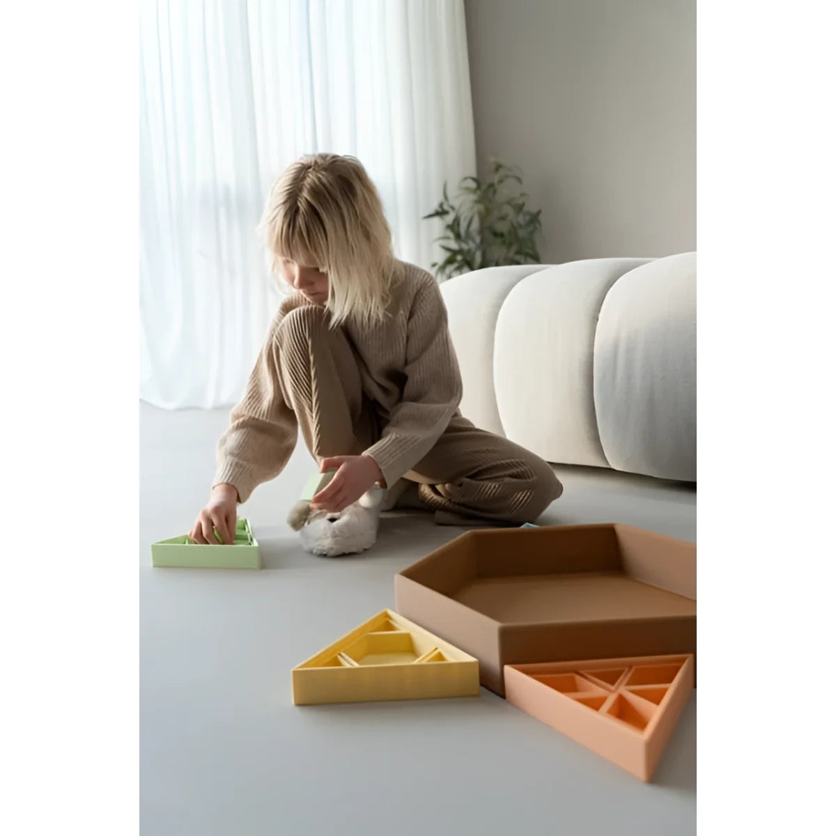 Ein kind spielt mit einer bunten sechseckigen mandigo spielschale aus plastik in einem hellen raum