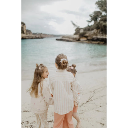 Drei Mädchen in nachhaltiger Babykleidung Schweiz, beige gestreifte Leinen-Shirts, Strand