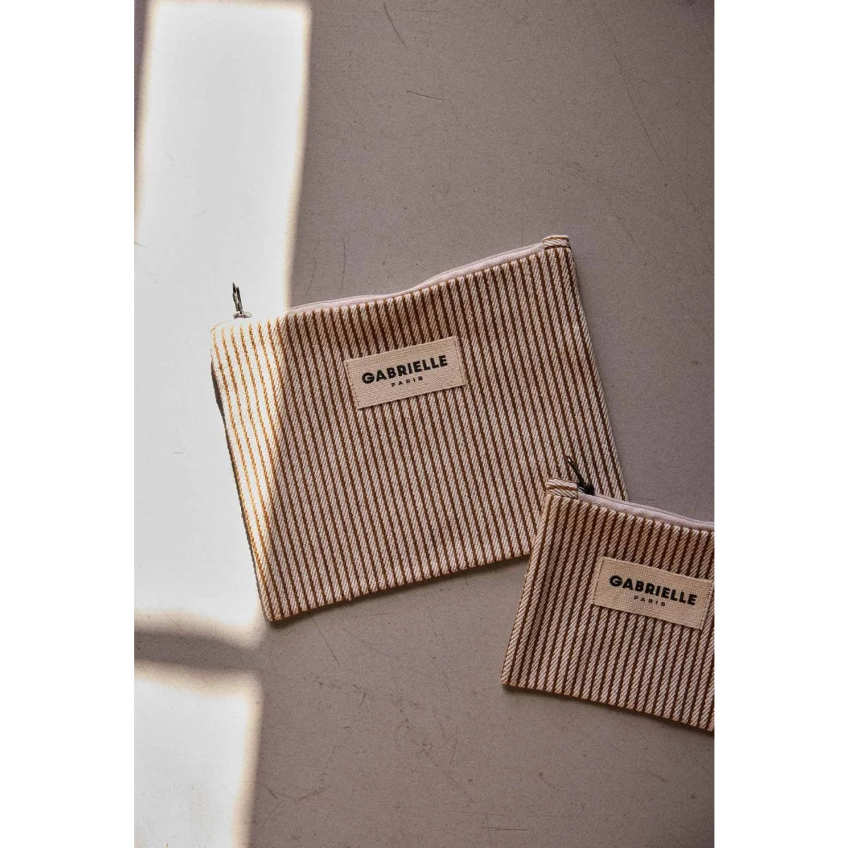 Kleine pouch argile stripes in beige und braun gestreift mit gabrielle paris etikett ideal für ökologische baby- & kinderprodukte