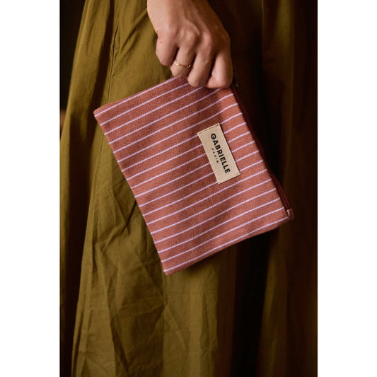 Kleine terrakotta-weiß gestreifte pouch aus gewebtem material mit beige etikett gabrielle paris für geschenke für neugeborene