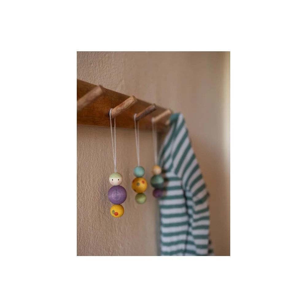 Holzregal mit bunten handgemalten Holzperlen an Schnüren vom Snowy Buddy