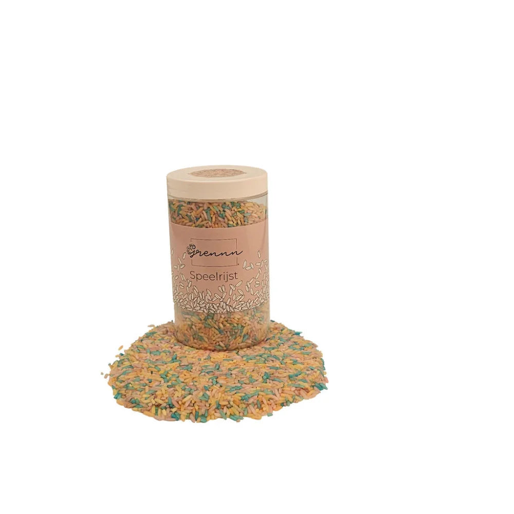 Klare Plastikdose mit buntem Pastel-Reis und verstreutem Reis am Boden