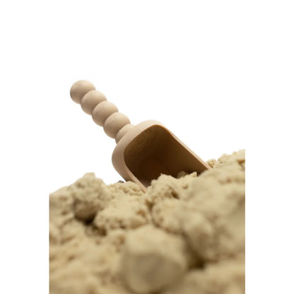 Leicht brauner Holz-Schaufelchen teilweise im hellbraunen Pulver eingebettet