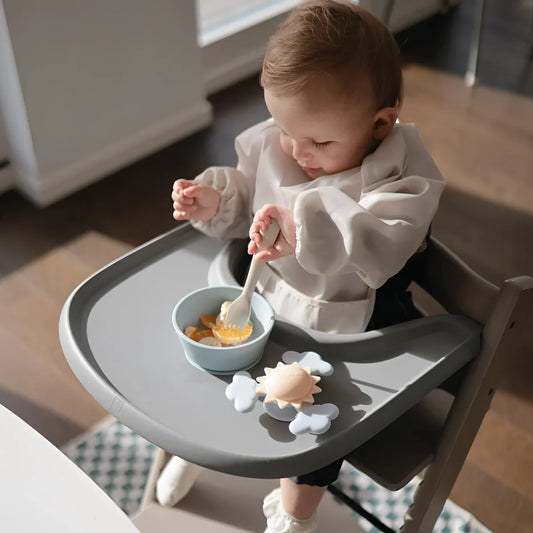 Grauer hochstuhl-tablett mit hellblauer schale und wolkenförmigen spielzeug saugnapf-spinner sonne passen