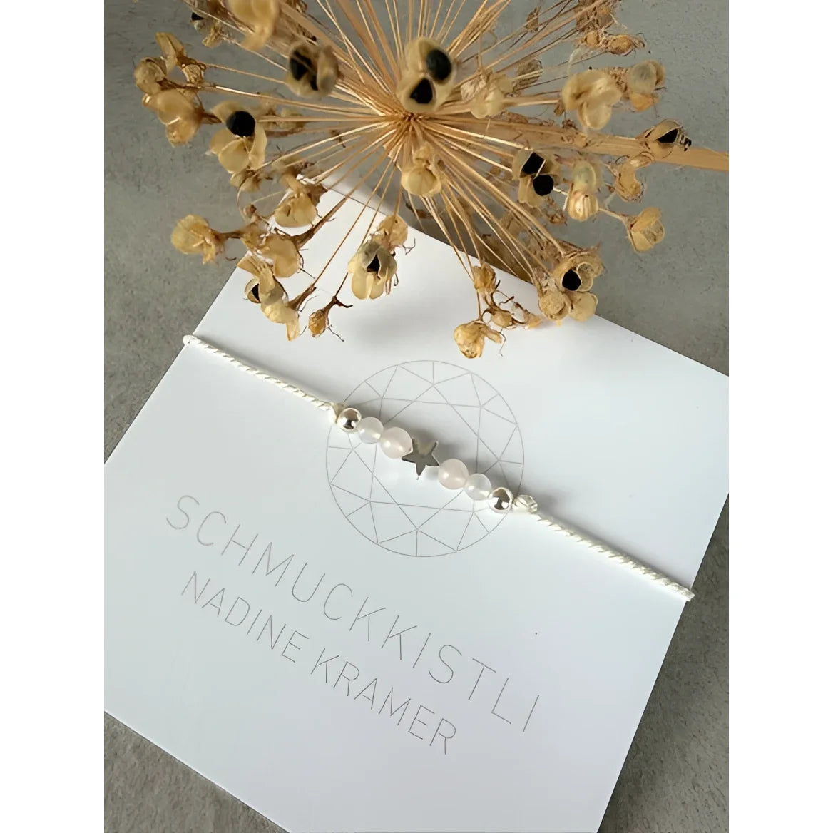 Weißes sternenarmband aus zartem kordband mit silbernen perlen ideal als geschenke für neugeborene