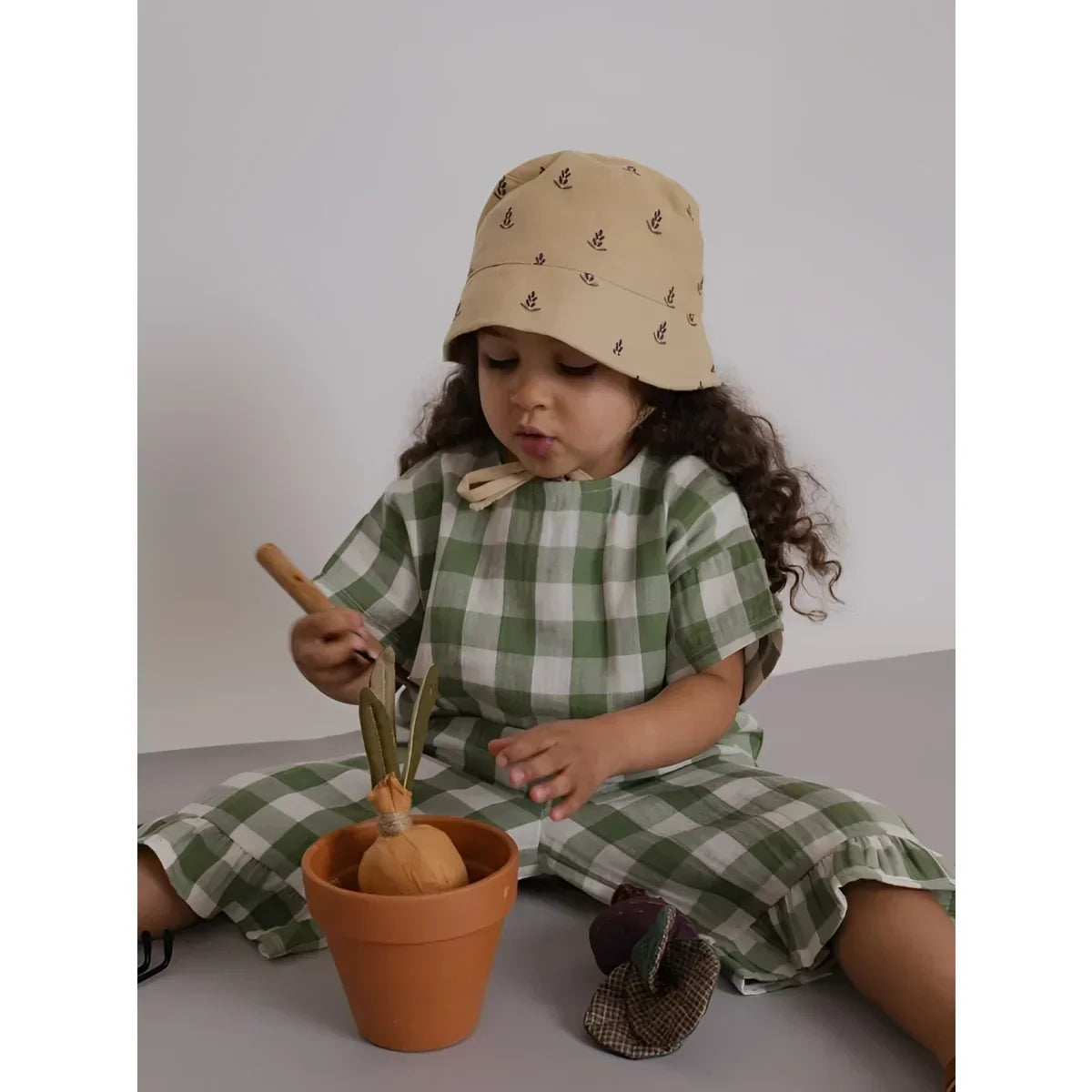 Kind auf der Rückseite trägt Beige Bucket Hat Sun Hat Bucket Lavender Bloom mit schwarzen Ankern