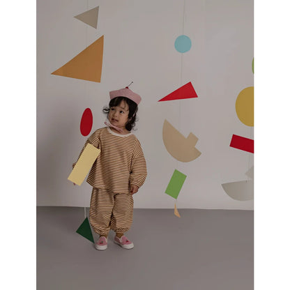 Kind trägt ein sweatshirt copper stripes in kupferfarben mit braun-creme gestreiftem zweiteiler und rot-weiß kariertem hut