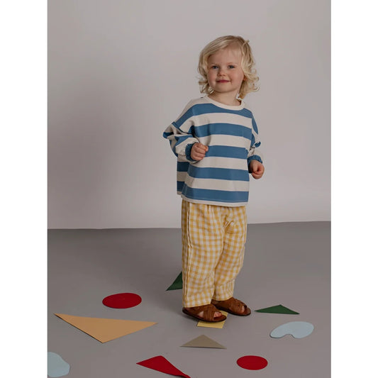 Kind trägt ein blau weiß gestreiftes sweatshirt mit rippenbündchen im muster deck chair stripes