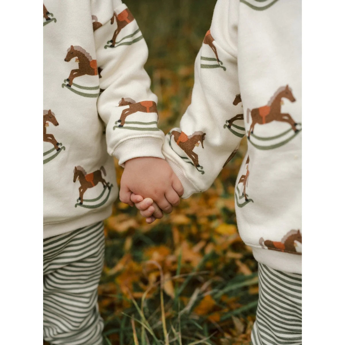 Weißer Sweatshirt mit braunen Schaukelpferd-Drucken und grünen Akzenten