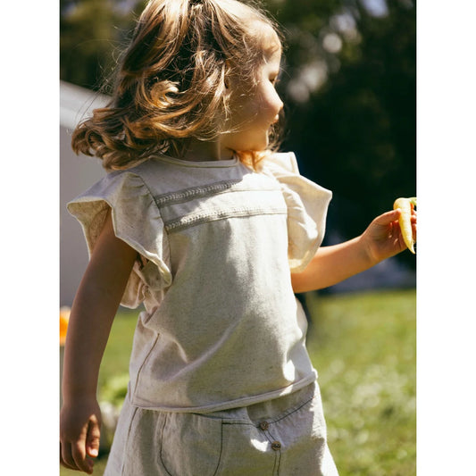 Kind mit T-Shirt aus Leinen, englischer Stickerei und eleganter Note