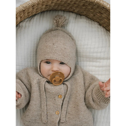 Süßes Baby mit beige gestricktem Tassel Wool Hat und Cardigan mit Schnuller