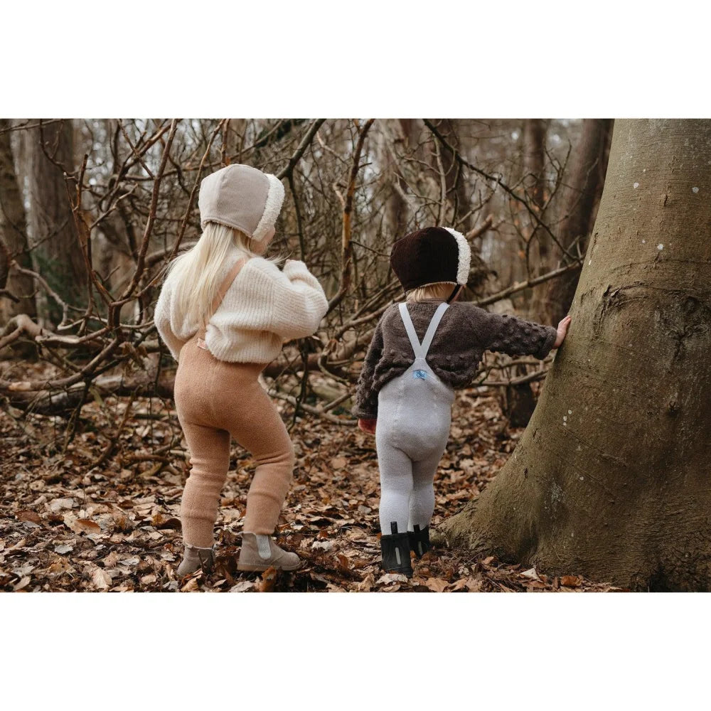 Zwei junge Kinder gehen gemeinsam in einem Wald, während sie Teddy Warmy Strumpfhosen tragen