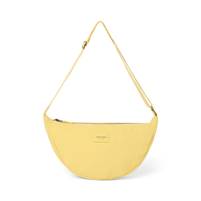 Texturierte puffy erwachsenen fanny pack buttergelb in blassem gelb mit minimalistischem crescent crossbody-design