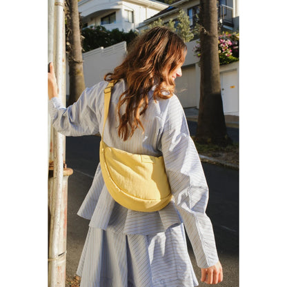 Ein buttergelber texturierter puffy erwachsenen bauchtasche aus weichem material mit verstellbarem gurt