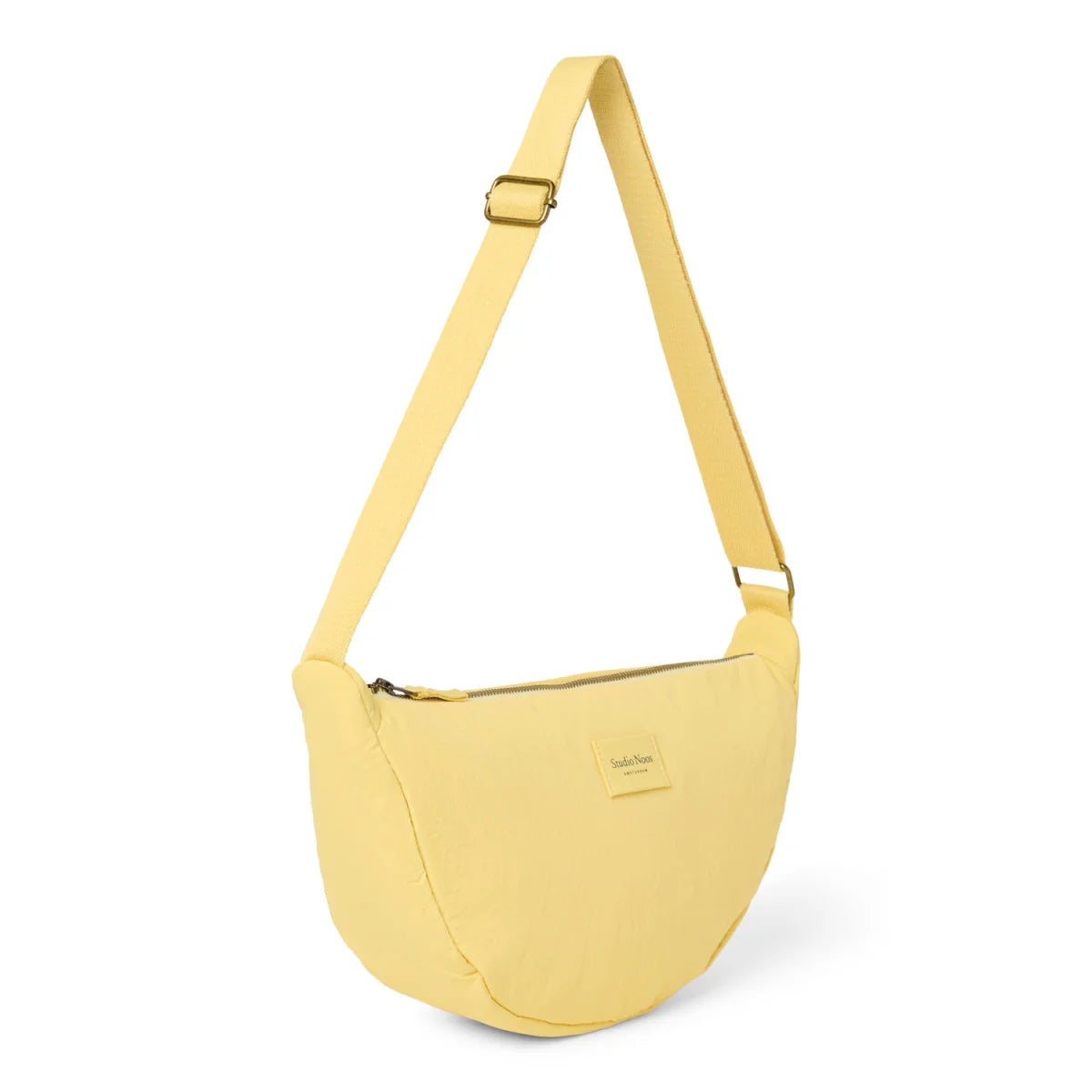 Gelbe texturierte gepolsterte crossbody tasche aus weichem material mit schlanker, geschwungener form und verstellbarem riemen