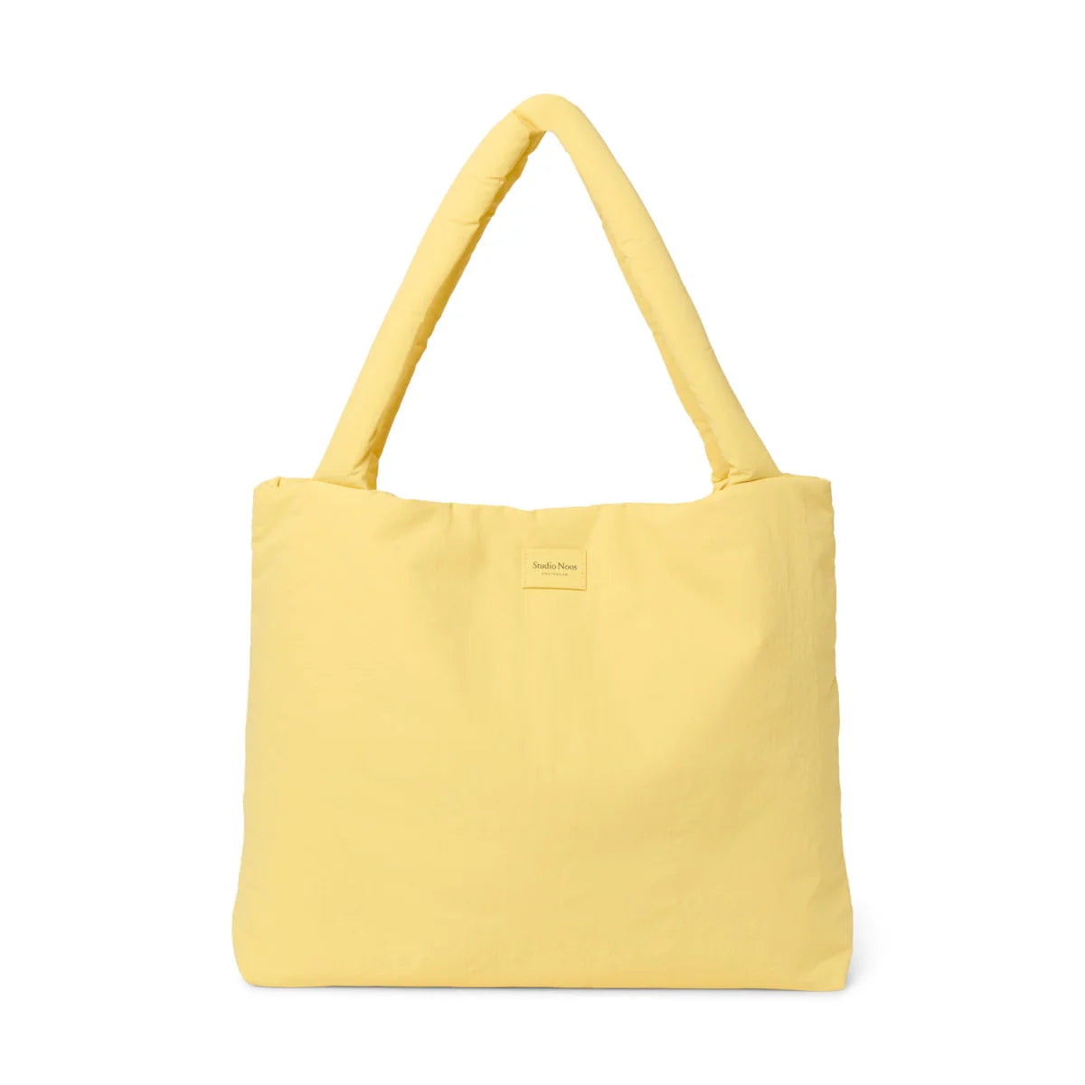 Ein weicher buttergelber gesteppter mom bag mit gepolsterten griffen und minimalistischem label