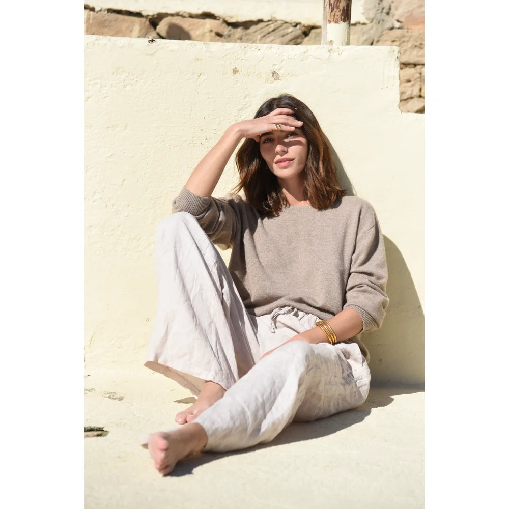 Frau trägt neutralfarbenes Langarmtop und lockere Hose in The Cashmere Cove Crew Neck Rye