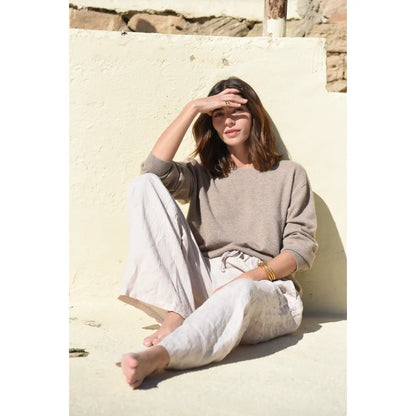 Frau trägt neutralfarbenes Langarmtop und lockere Hose in The Cashmere Cove Crew Neck Rye
