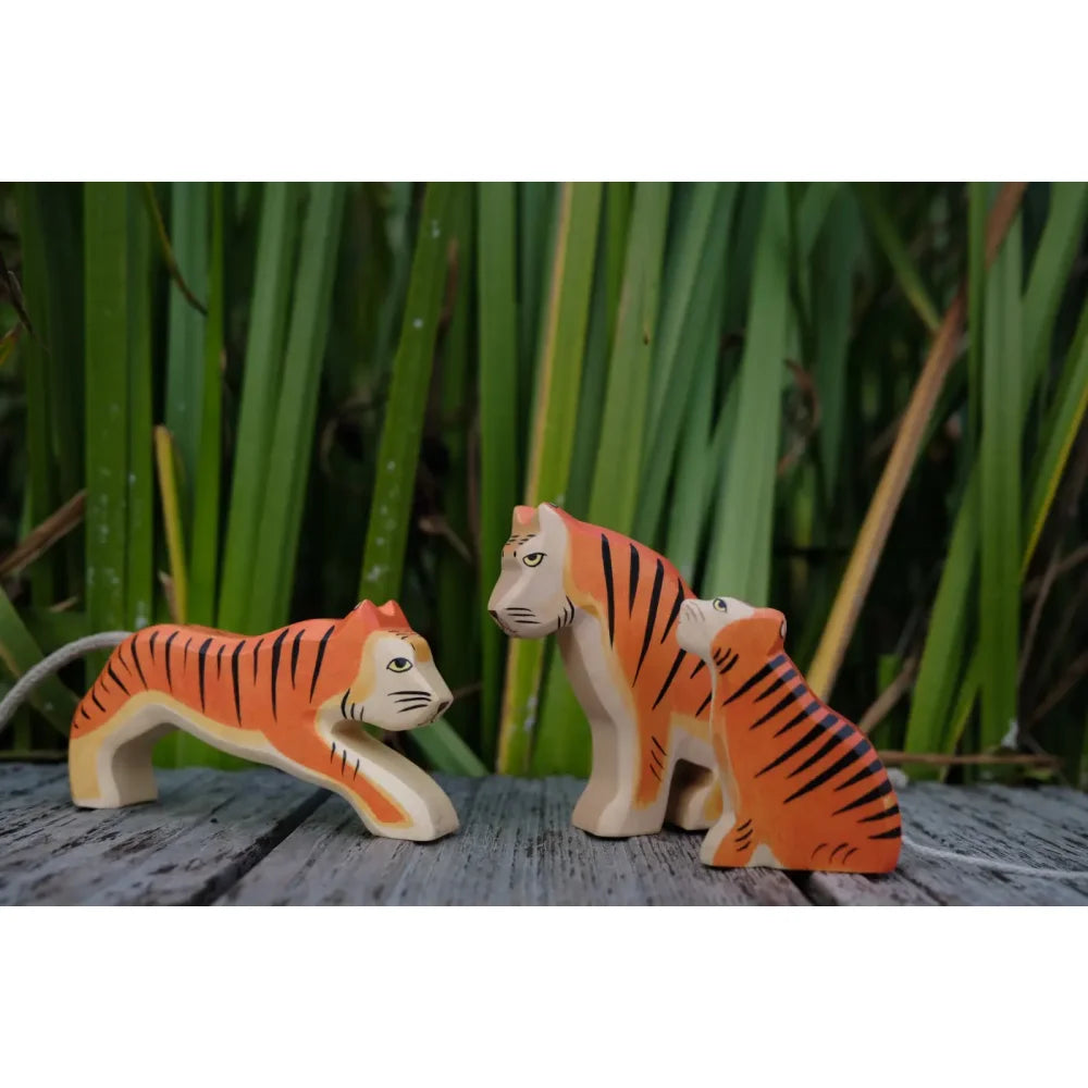 Drei handbemalte hölzerne Tiger-Figuren mit orange und schwarzen Streifen