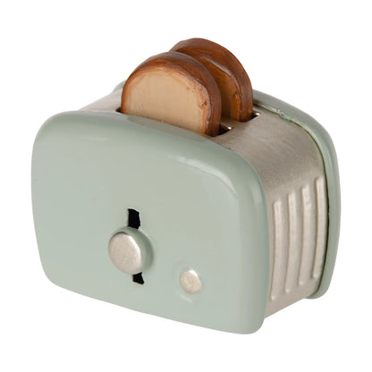 Pastelgrüner mini toaster toster maus mit silbernen akzenten und zwei getoasteten brotscheiben ideal als geschenk für neugeborene