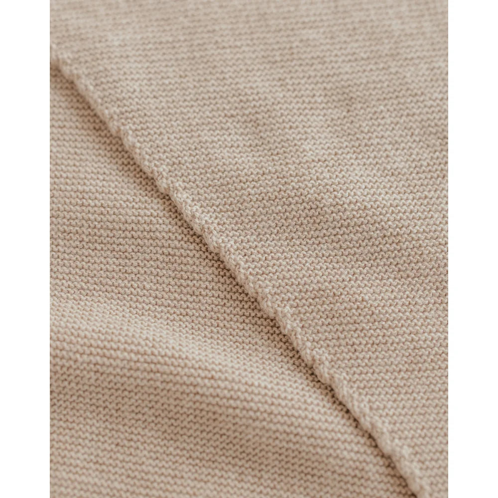 Nahaufnahme von hellbeigem, fein gestricktem Stoff beim Triangle Schal Josephina Sand