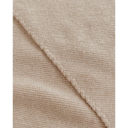 Nahaufnahme von hellbeigem, fein gestricktem Stoff beim Triangle Schal Josephina Sand