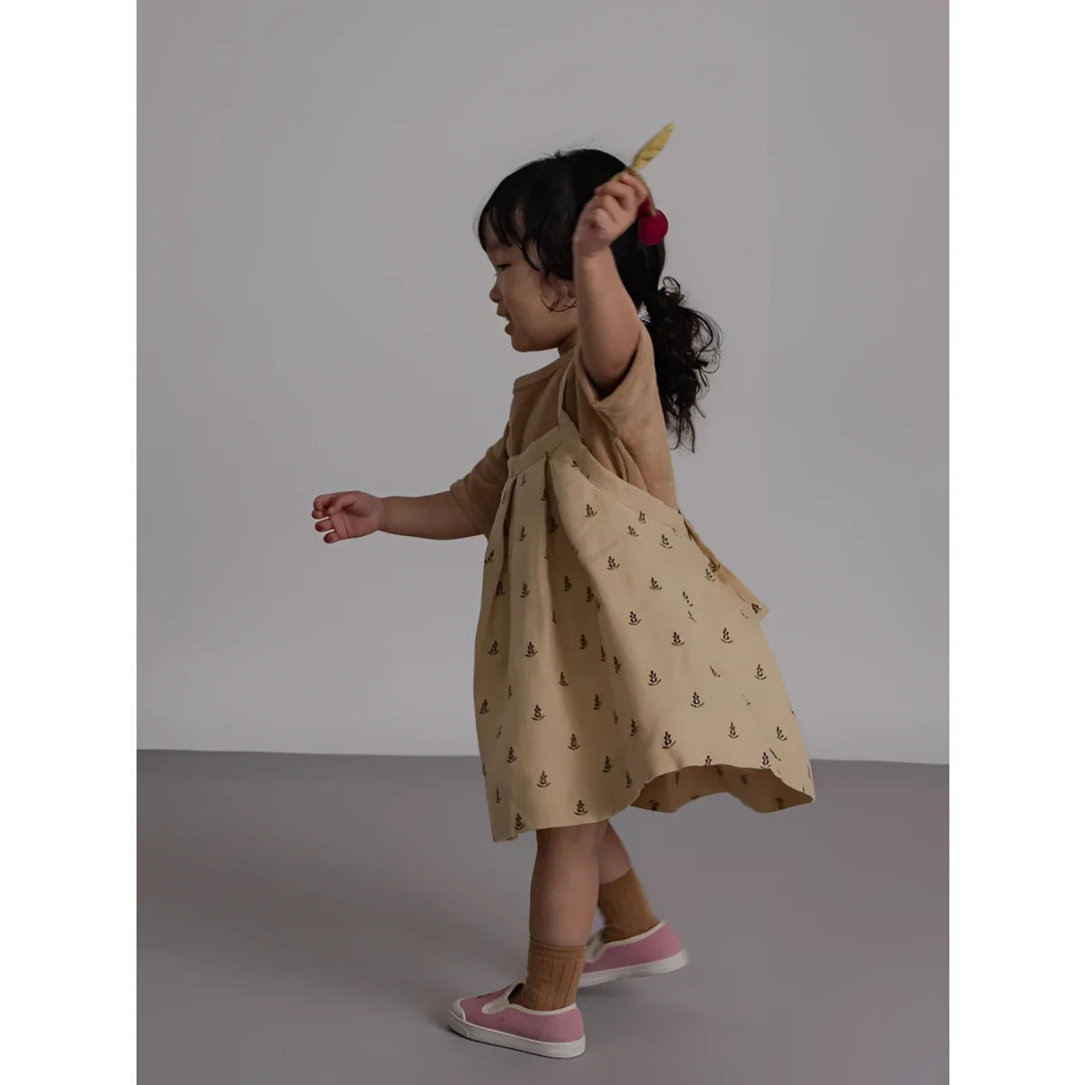 Kind mit Tribe Rock | Lavender Bloom in Beige-Kleid mit brauner Stickerei und rosa Schuhen