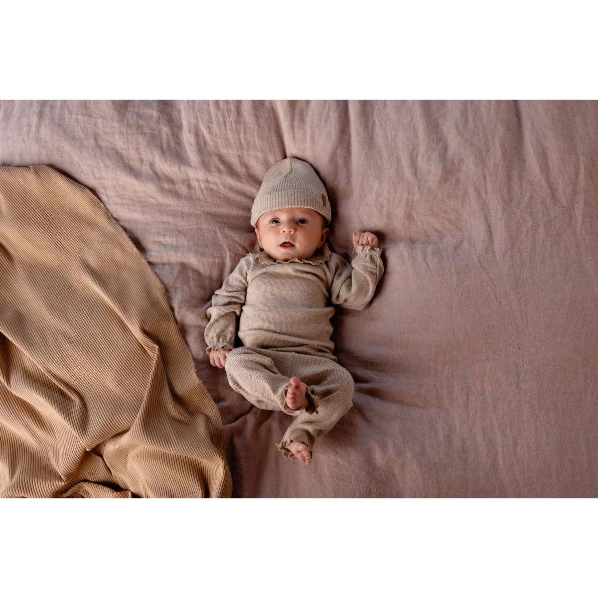 Baby in beiger Tub Legging mit passendem Strick-Outfit für stilvolle Kleinkinder