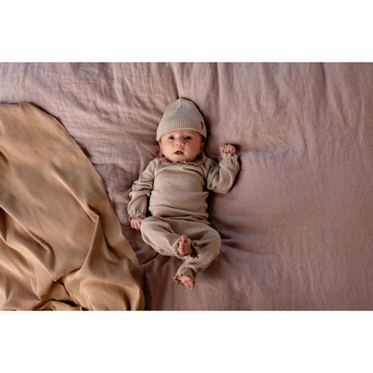 Baby in beiger Tub Legging mit passendem Strick-Outfit für stilvolle Kleinkinder