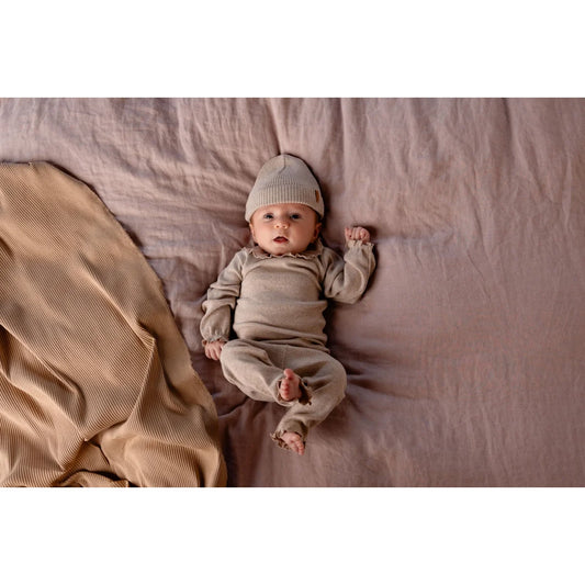 Baby in beiger Tub Legging mit passendem Strick-Outfit für stilvolle Kleinkinder