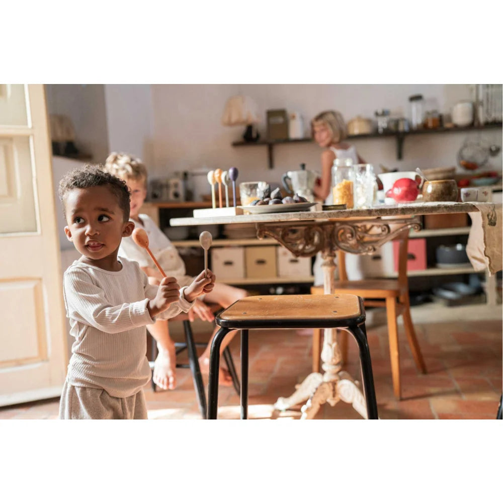 Kleines Kind hält zwei Holzlöffel von Twin-souls Puppets