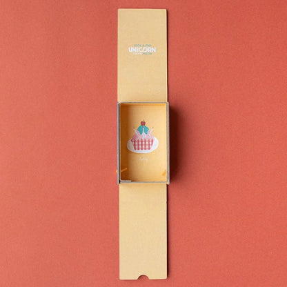 Gelber Karton-Streichholzschachtel mit Cupcake-Motiv und Look & Find Unicorn Text auf Klappe für Unicorn Tiny Puzzle