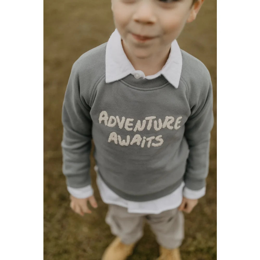 Grauer Unisex Oversized Sweatshirt mit Abenteuer wartet Design, weißem Kragen und Bündchen