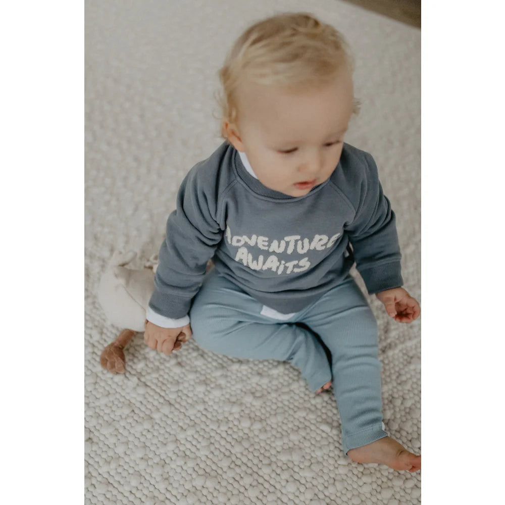 Babyblaues und graues Adventure awaits Babysuit auf dem Unisex Oversized Sweatshirt Blau