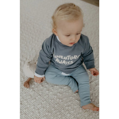 Babyblaues und graues Adventure awaits Babysuit auf dem Unisex Oversized Sweatshirt Blau