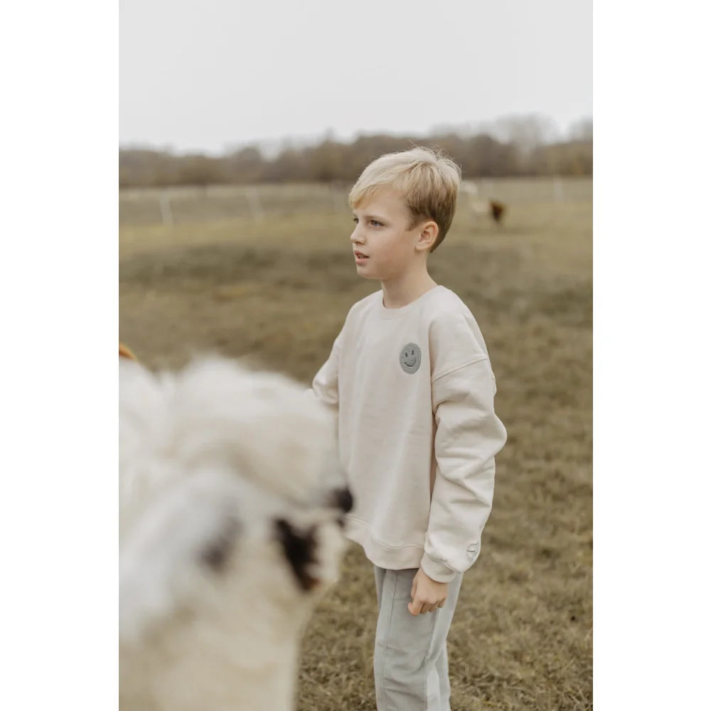 Helle cremfarbene Unisex Oversized Sweatshirt mit kleinem Logo auf der Brust