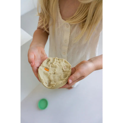 Kinderhände mit hellgrünem Playdough und orange Akzenten, ideal für Little Botanic Label
