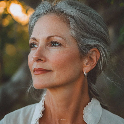 Hand hält texturierte Silber-Odelia-Kreolen mit hammerter Oberfläche