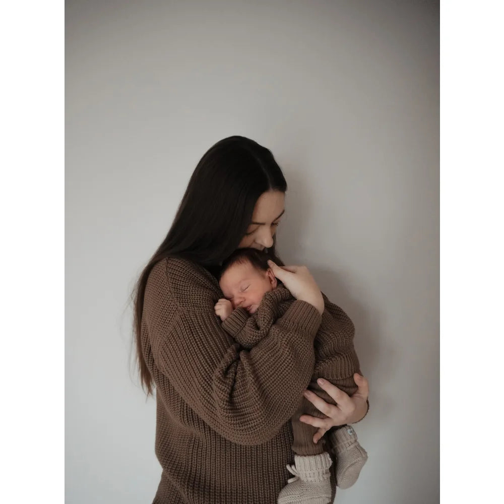 Mutter hält neugeborenes Baby in braunen Strickoutfits, passend zum Women Chunky Knit Sweater