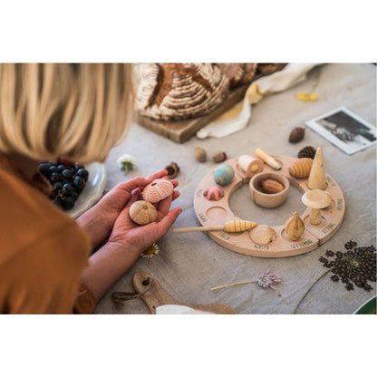 Holzernes rundes Spielzeug mit geschnitzten Jahreszeiten und Monatsbeschriftungen aus Wonders